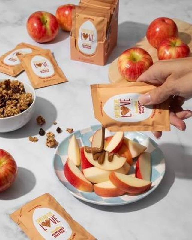 Almond butter sachets and sliced apples on a plate